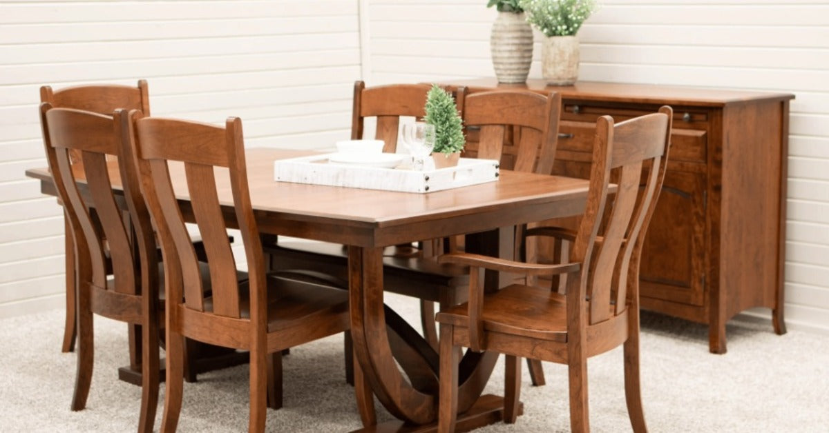 A square wooden dining table with six chairs, a sideboard, white tray, dishes, glasses, and potted plants.