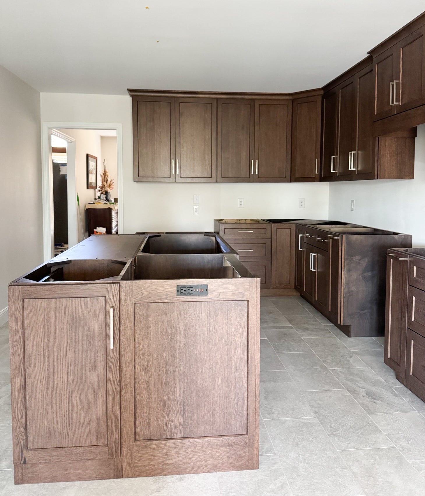 The kitchen shows a view of newly installed custom wood cabinets with stain.