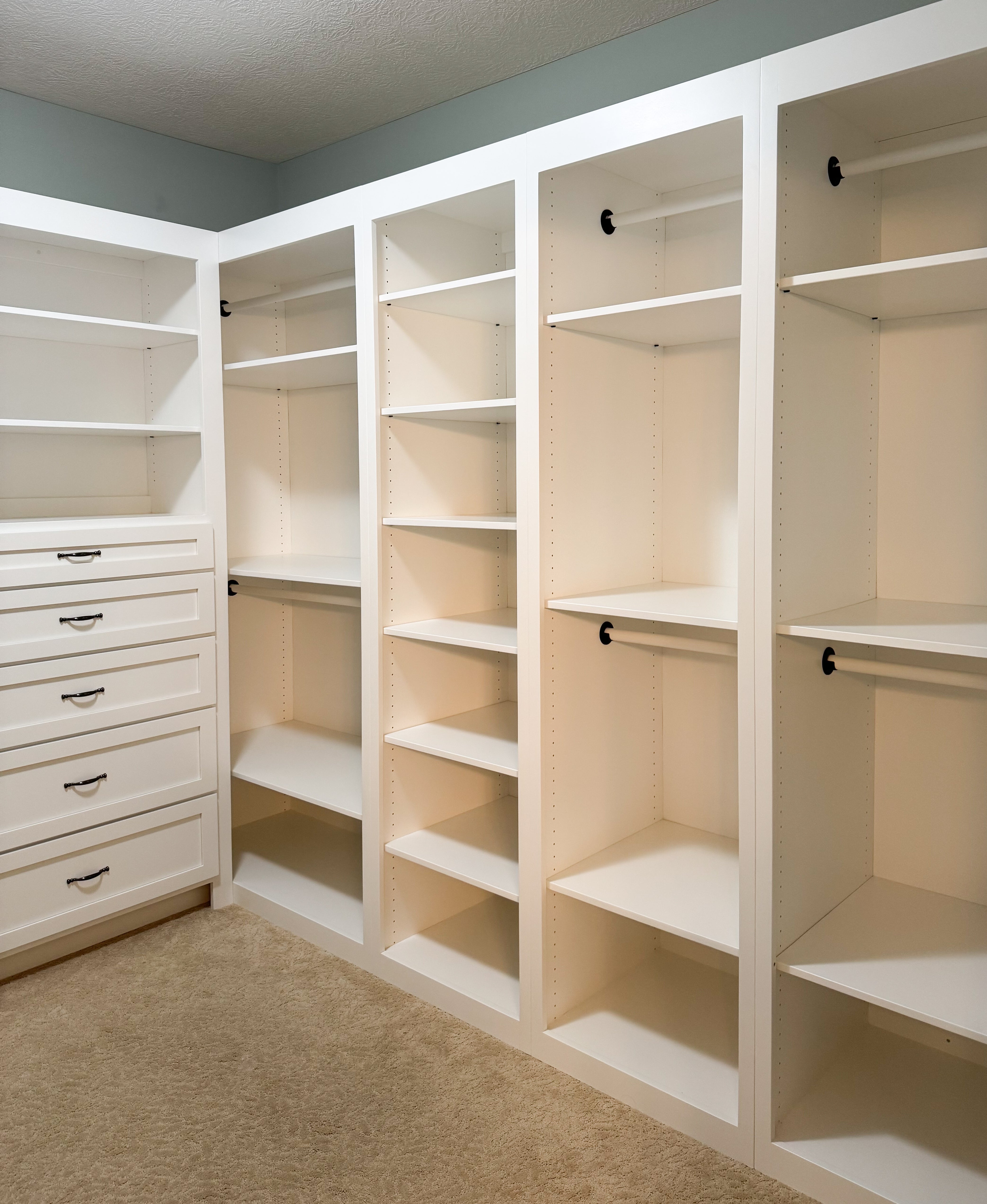 A view of white built in shelves in a new spacious wardrobe area.