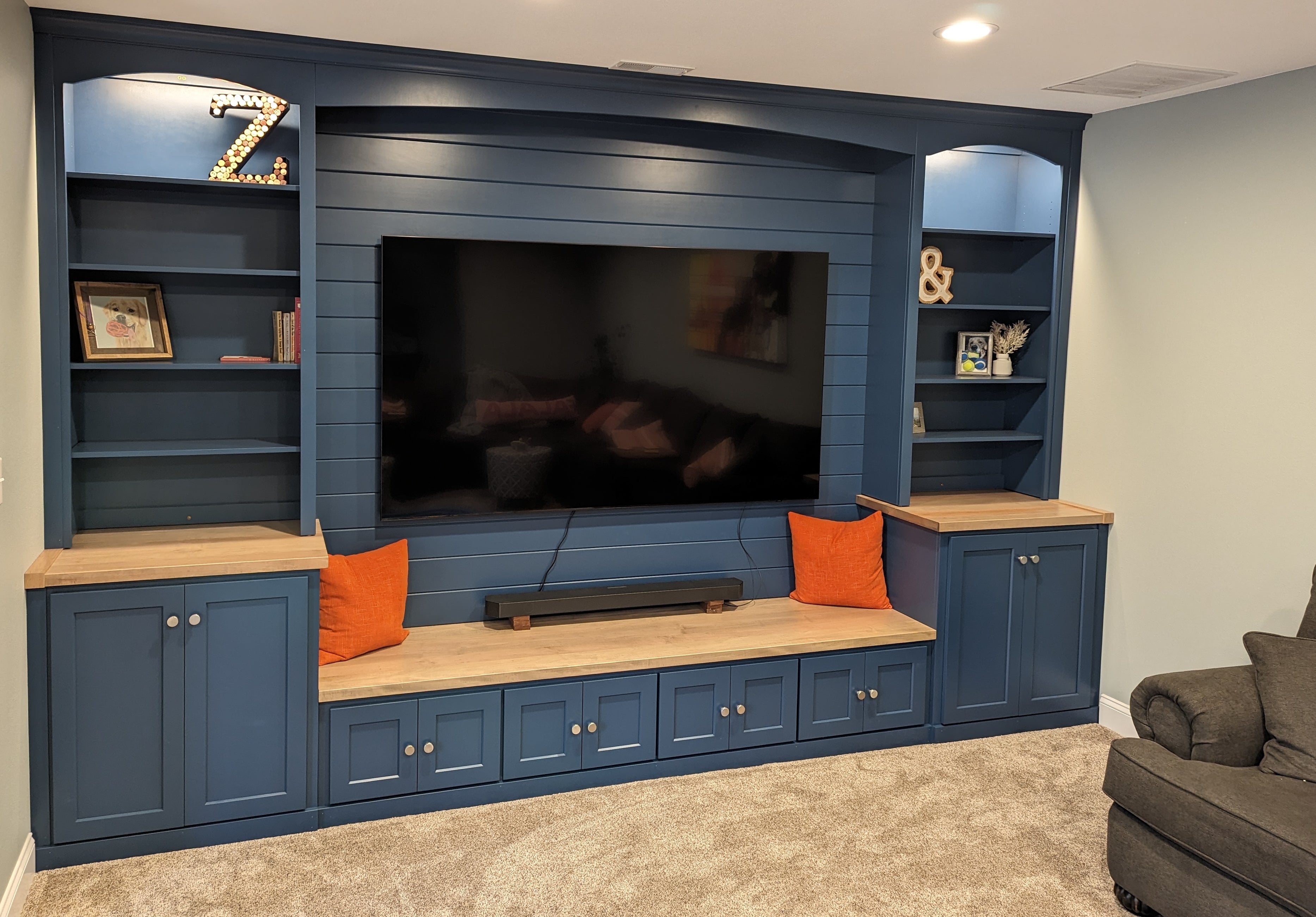 The wall-to-wall entertainment center is installed and decorated in the customer's home.