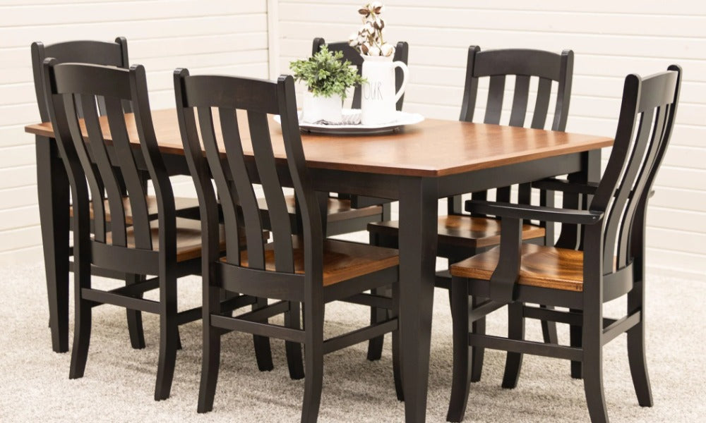 A rectangular dining table with a brown wooden top and black legs surrounded by six black chairs with wooden seats.