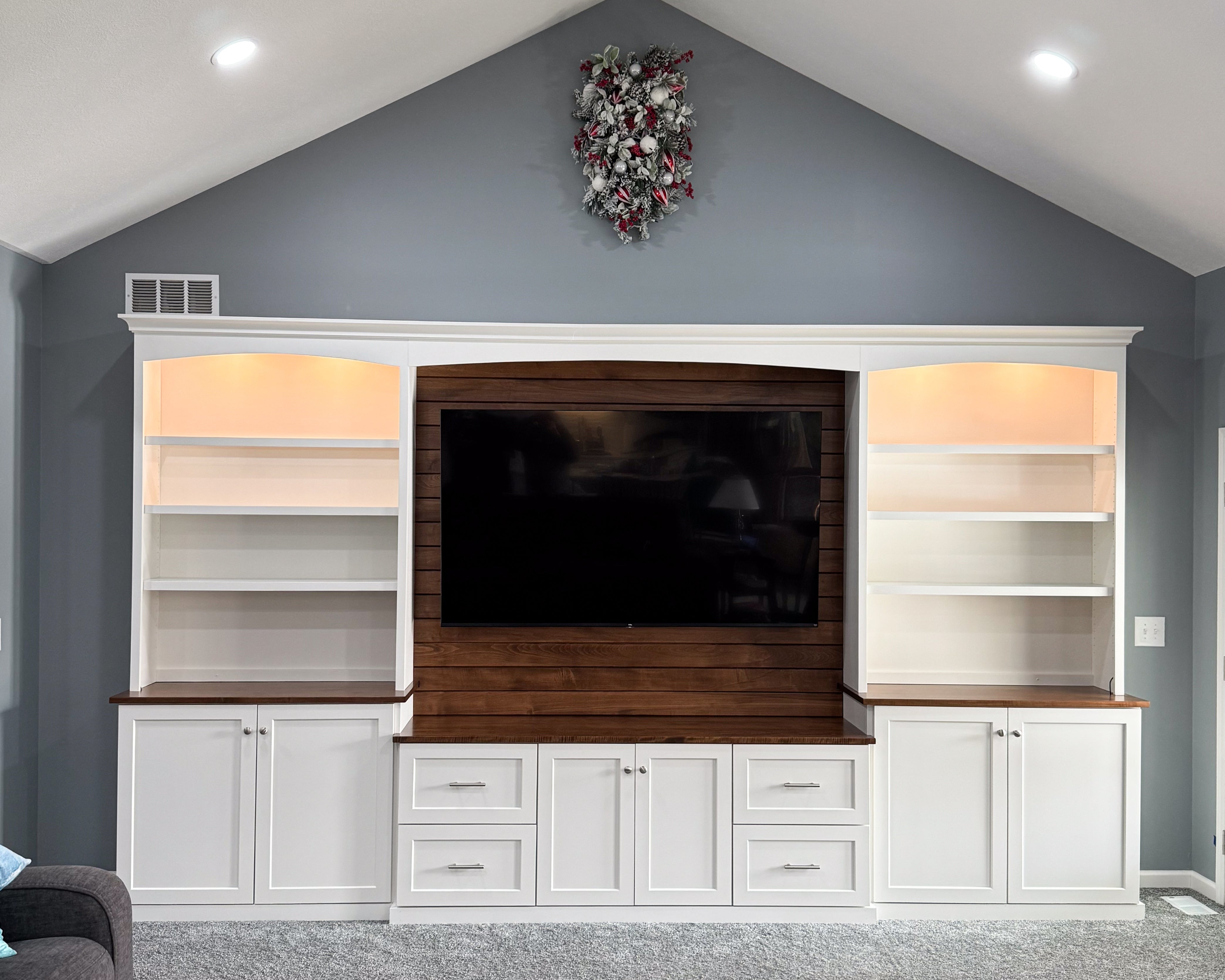 The blank wall is filled with a large custom entertainment center with side bookcases.