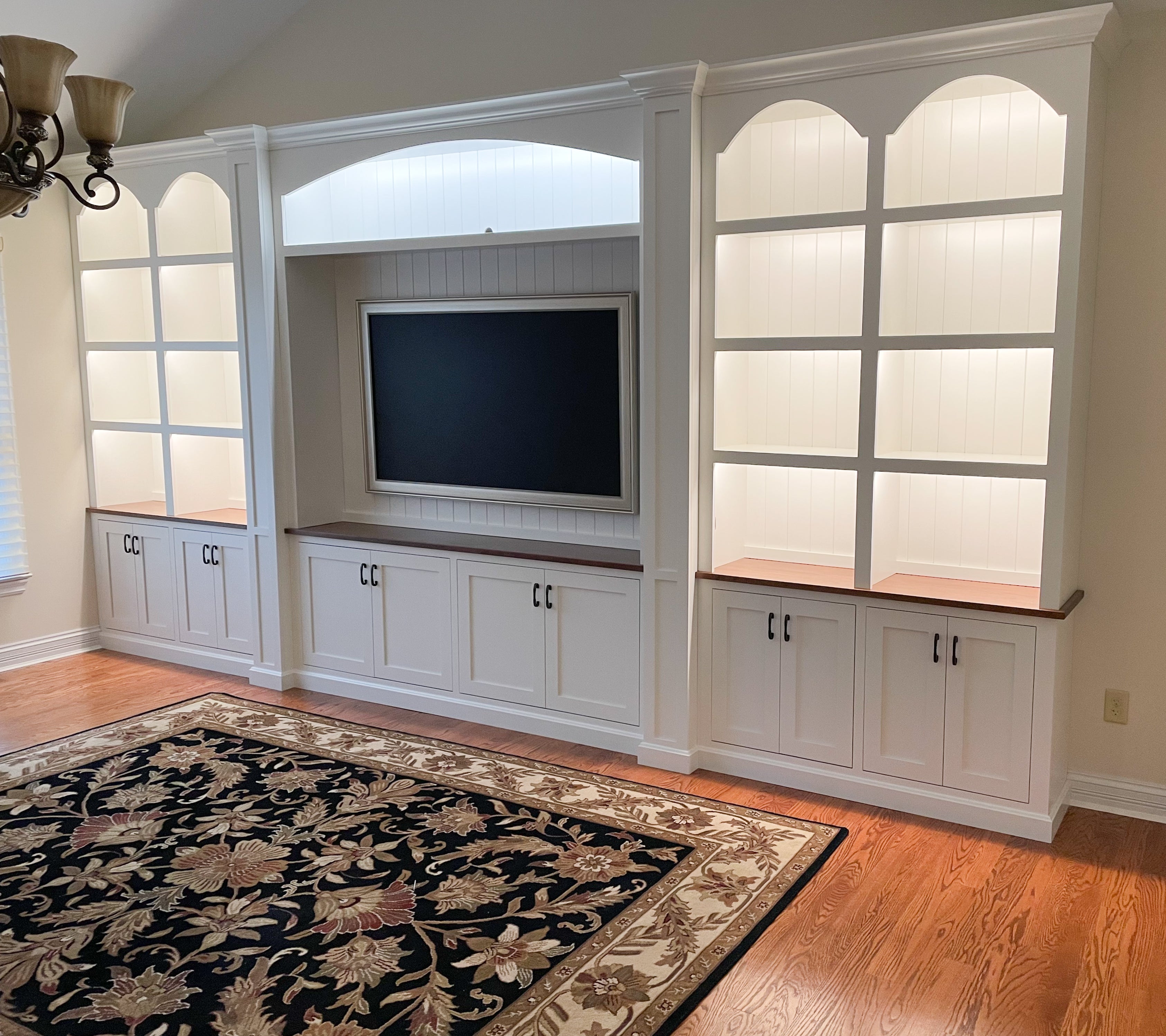 The beautiful, white painted custom bookcase entertainment center displays the added lights.